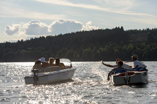 Silhouette of group of friends racing with powerboats on lake
