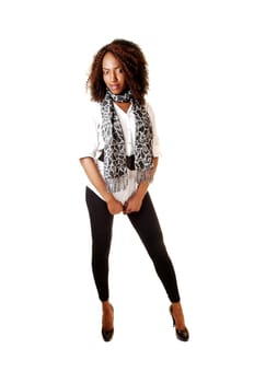 A very tall black teenager girl standing in black tights and white blouse for white background and looking into the camera.