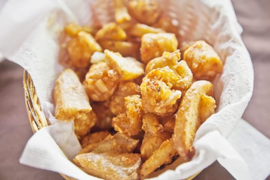 Horizontal capture of various styles and type of potato deep fried and presented in on a serviette in a basket
