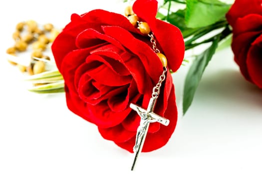 Rosary and rose on a white background