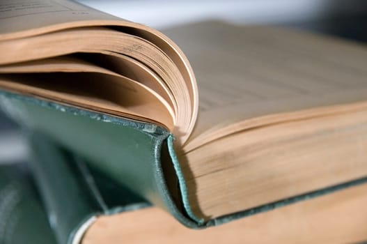 Close-up of a small stack of books of green bound old books  top book also struck