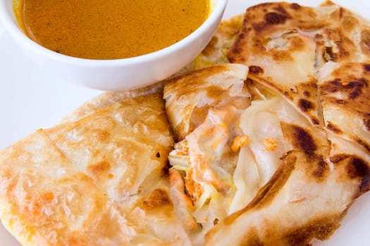 Indian Roti Prata with Chicken Meat and Curry Sauce Closeup