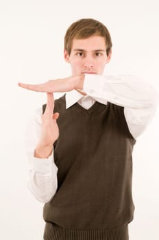 Frontal upper body view of young man in white shirt and brown vestover showing time-out hand signal to camera against white background