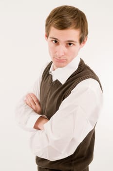 Side torso shot of a young man in a white shirt and brown westover with crossed arms looking provocatively towards the camera