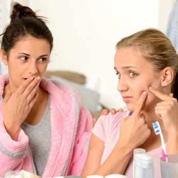 Young teenager and her friend squeeze pimple in the bathroom