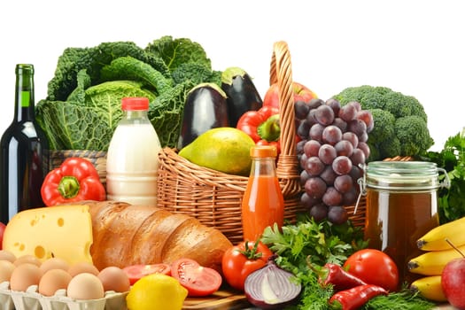 Groceries in wicker basket including vegetables, fruits, bakery and dairy products and wine isolated on white