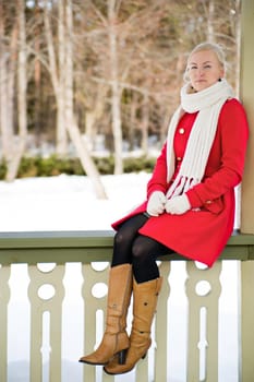 Woman in red coat sit at terrace boundary