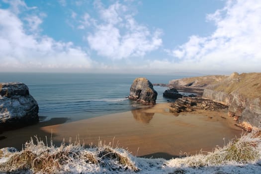 snow covered view of beach cliffs and the virgin rock in ballybunion county kerry ireland