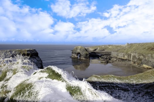 snow covered view of beach cliffs and the virgin rock in ballybunion county kerry ireland