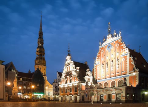 Beautiful old architecture of the central square of Riga. Night view with blue cloudy sky in background and illuminated buildings in foreground. Riga, Latvia, Baltic, Europe.