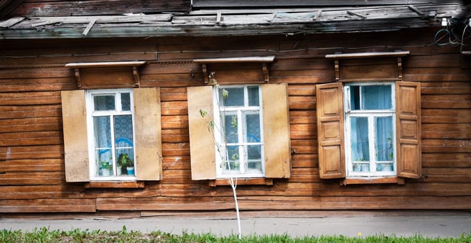 Old traditional wooden house with three open windows. Kostroma, golden ring, Russia.