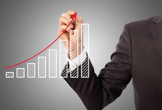 Male hand drawing a graph, grey background