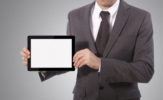 business man with blank touch tablet in hands, grey background