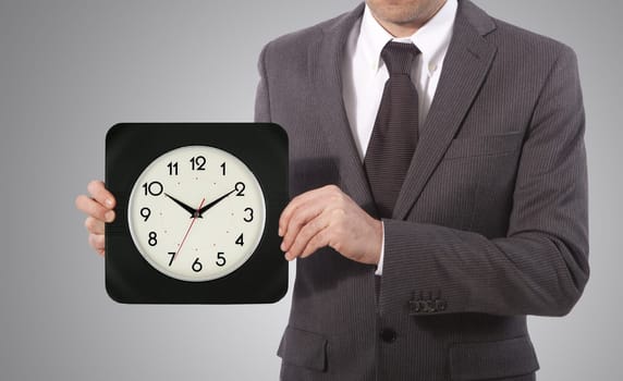 business man with wall clock on his hand, grey background
