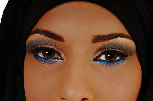 A closeup shoot of the beautiful eyes of a teen girl with a black headscarf and nice makeup, looking into the camera.