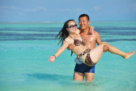happy young asian couple have fun and romantic time at  summer on beautiful white sand beach