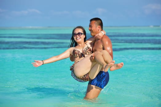 happy young asian couple have fun and romantic time at  summer on beautiful white sand beach