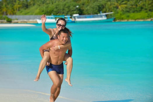 happy young asian couple have fun and romantic time at  summer on beautiful white sand beach
