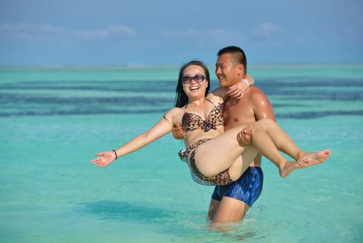 happy young asian couple have fun and romantic time at  summer on beautiful white sand beach