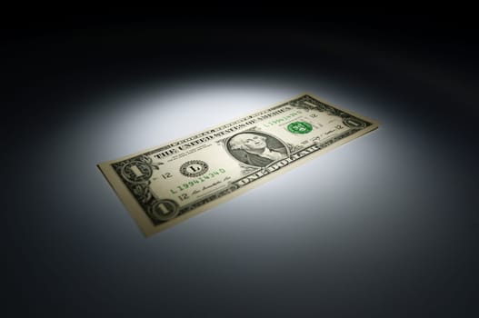United states one dollar bank note on dark background under spot light