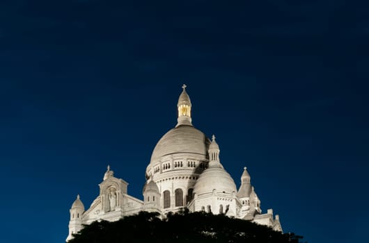 Night view of Basilica of the Sacred Heart of Paris with deep blue sky (Paris, France, Europe).