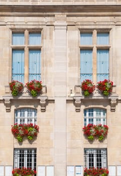 beautiful exterior of old building with large windows and flowers. Paris, France, Europe.