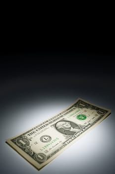 United states one dollar bank note on dark background under spot light