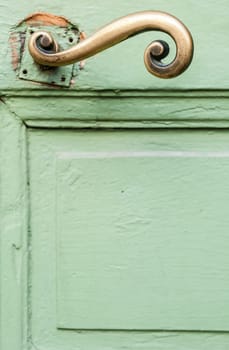 Fragment of green door and golden handle. Nice, France, Europe.
