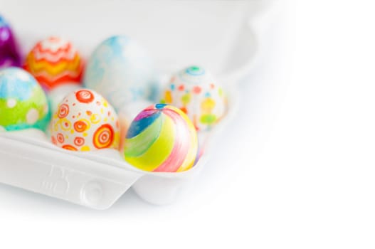 colorful painted easter eggs in white crate. Isolated on white background. A lot of copy space.