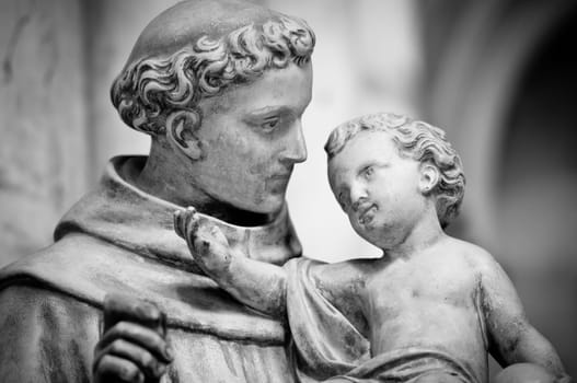 Statue of man holding small boy on his hands. Sculpture from Saint Denis cathedral. Paris, France, Europe.