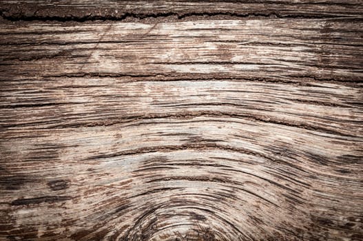 Old wood background with cracks and lines. Light in the middle with space for copy, dark at the sides.
