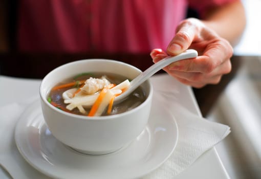 Women eating chinese chicken soup close up