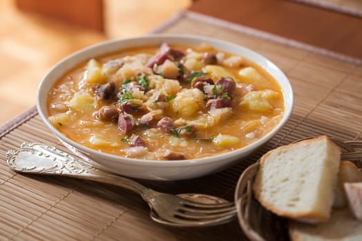 Fresh cabbage stew with potatoes, meat and beans close up