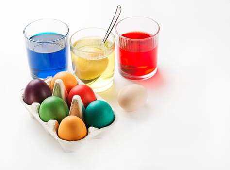 Easter eggs dyeing in glass with colors