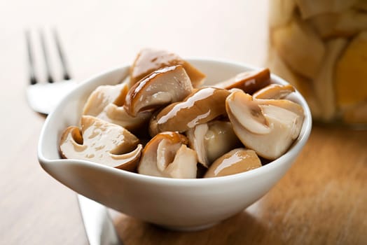 Canned boletus mushrooms in a bowl close up shoot
