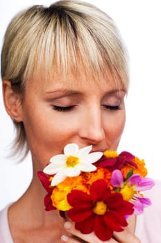 young blond woman smelling flowers close up