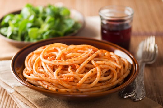 Fresh spaghetti with tomato sauce on a plate close up