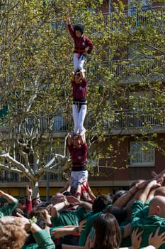SANT CUGAT, SPAIN - APRIL 07: Some unidentified people called Castellers do a Castell or Human Tower, typical tradition in Catalonia, on April 07, 2013 in Sant Cugat, Spain.