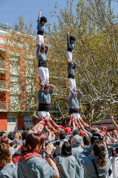 SANT CUGAT, SPAIN - APRIL 07: Some unidentified people called Castellers do a Castell or Human Tower, typical tradition in Catalonia, on April 07, 2013 in Sant Cugat, Spain.