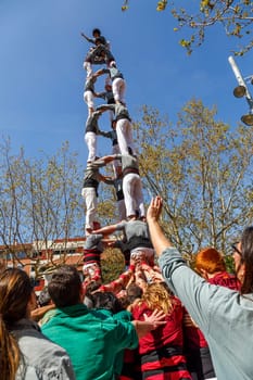 SANT CUGAT, SPAIN - APRIL 07: Some unidentified people called Castellers do a Castell or Human Tower, typical tradition in Catalonia, on April 07, 2013 in Sant Cugat, Spain.