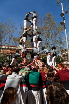 SANT CUGAT, SPAIN - APRIL 07: Some unidentified people called Castellers do a Castell or Human Tower, typical tradition in Catalonia, on April 07, 2013 in Sant Cugat, Spain.