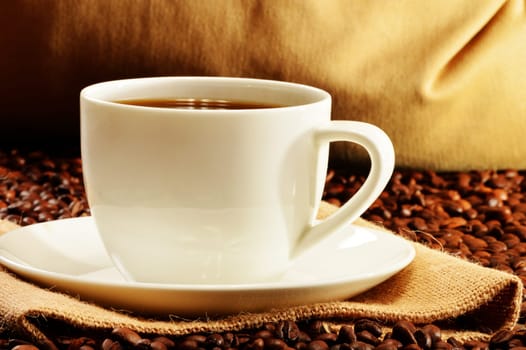 Composition with white cup and coffee beans
