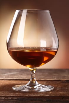 Glowing golden brown cognac served in a snifter as a luxury after dinner beverage