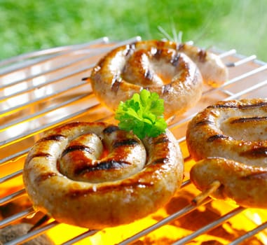 Close up shot of spiral sausages on the grilling pan