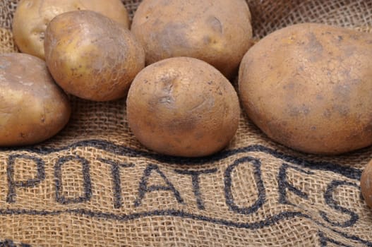 potatoes on burlap sack with inscription