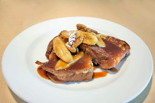 French Toast with Sliced Bananas Walnuts Powdered Sugar and Caramel Sauce Breakfast Dish