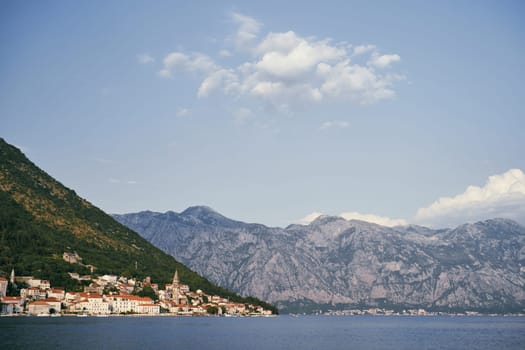 View from the sea to the ancient town of Perast at the foot of the mountains. Montenegro. High quality photo