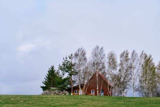 Cozy house among trees on a green meadow. High quality photo