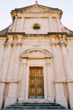 Facade of the Church of the Our Lady Birth with a wooden door. Prcanj, Montenegro. High quality photo