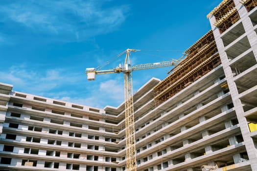 Large tower crane builds a corner high-rise residential complex. High quality photo